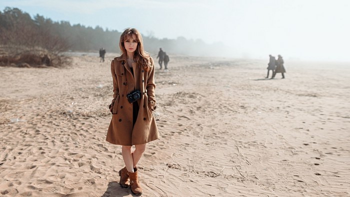 Woman with camera on a sandy beach