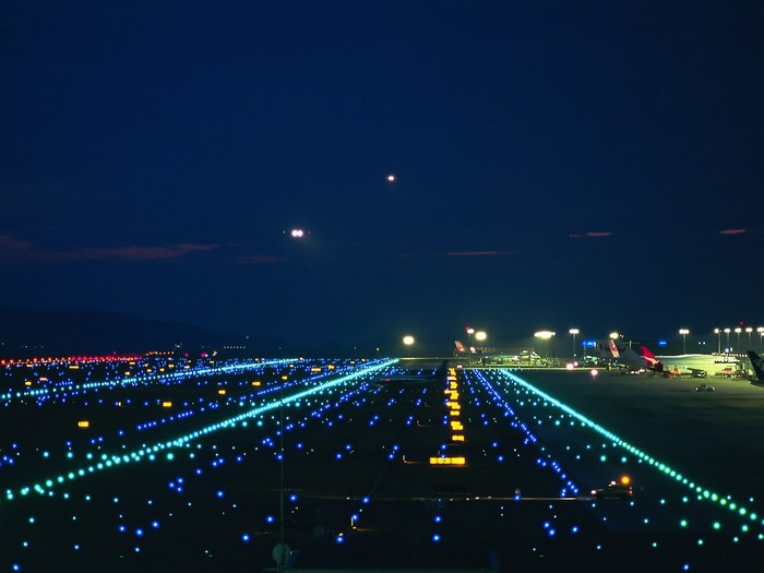 Airport runway lights at night with airplanes