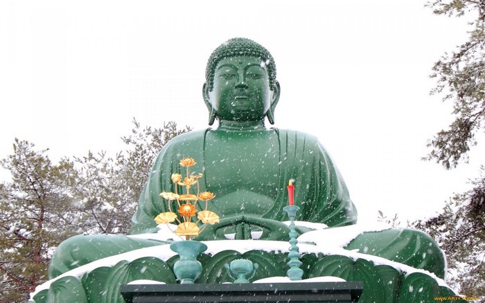 Green Buddha statue in snow