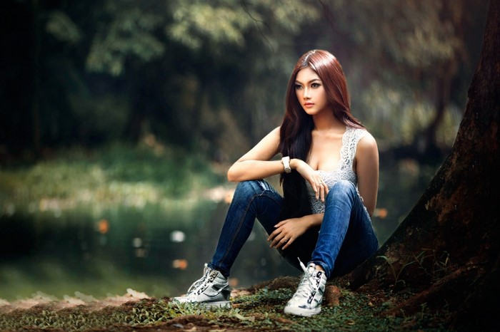 Contemplative Woman Sitting in Forest Sunlight
