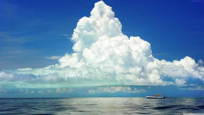 Boat on the sea under cumulus clouds