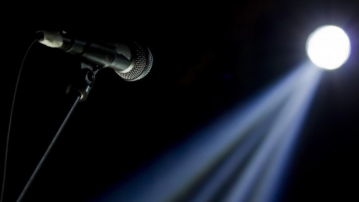 Microphone on a stand illuminated by a spotlight