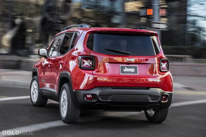 Red Jeep Renegade 4x4 driving on a city street