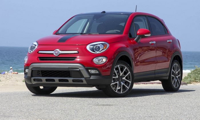 Red Fiat 500X parked on a road near a beach