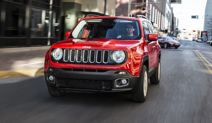 Red Jeep Renegade driving on a city street