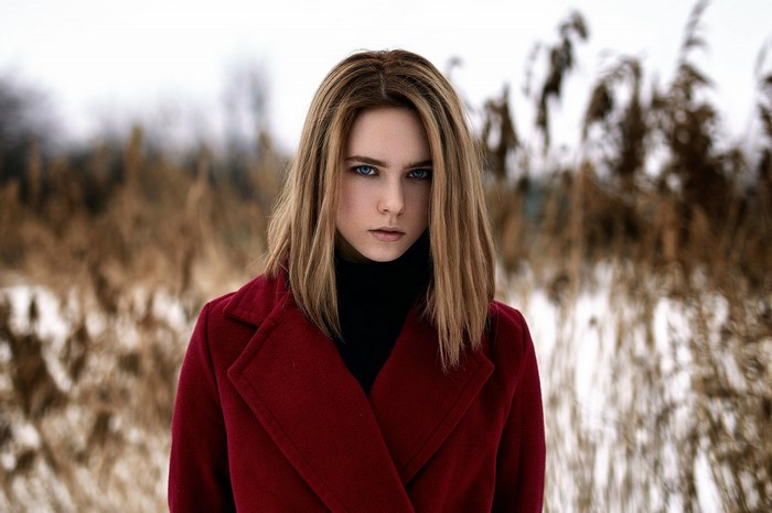 Woman in red coat in winter field