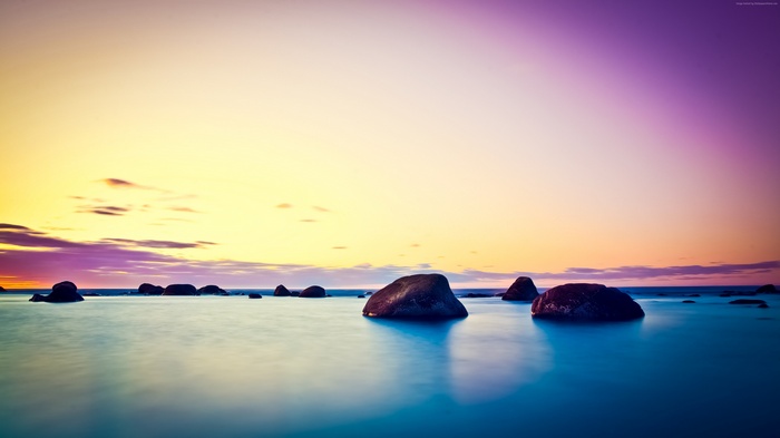 Ocean sunset with rocks and colorful sky