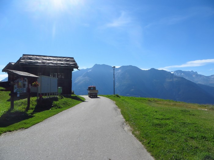 Road to the Alps with a truck and a wooden house