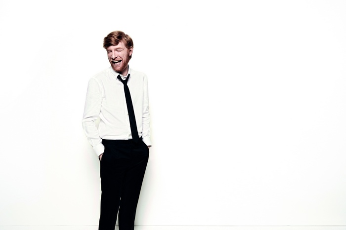 Domhnall Gleeson in a white shirt and black tie