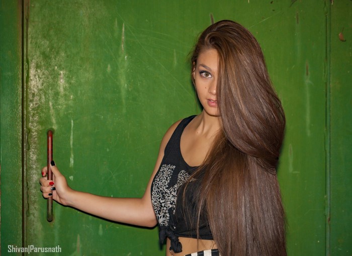 Woman with long brown hair holding a door handle