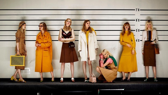 Women posing in fashion outfits against a height chart