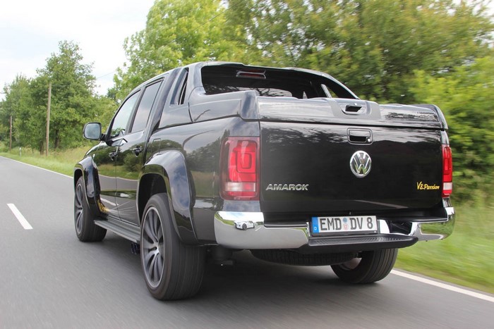 Black Volkswagen Amarok pickup truck driving on a road