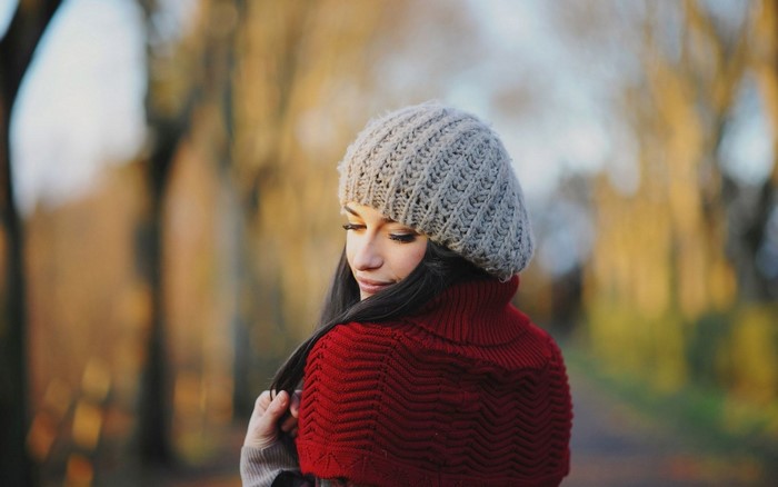 Woman wearing a knit hat and red sweater in autumn