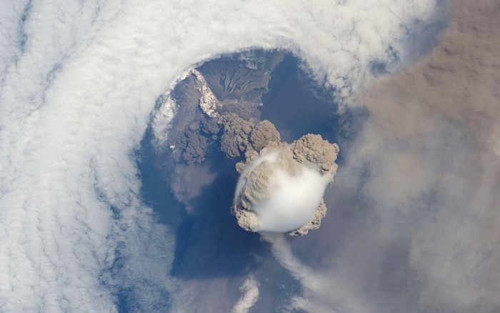 Volcanic eruption viewed from space with ash cloud