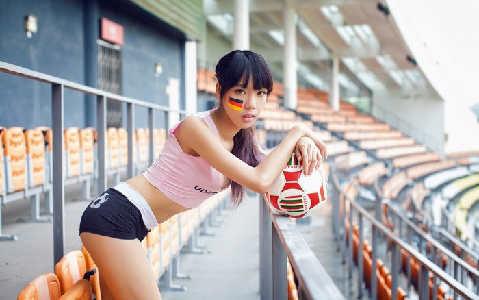 Asian woman with German flag face paint at stadium
