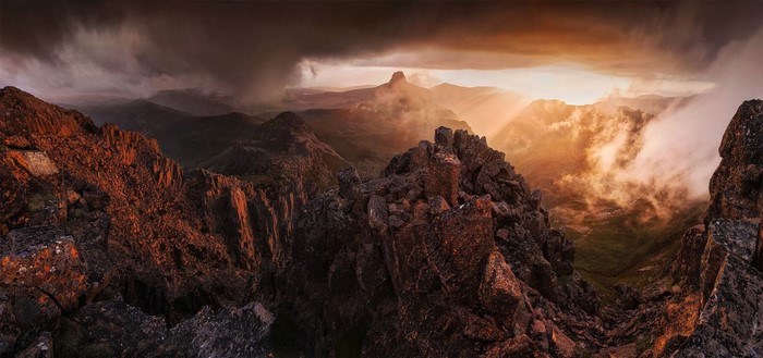 Dramatic mountain landscape at sunrise with storm clouds