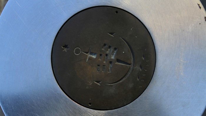 Close-up of a metal plate with an anchor emblem