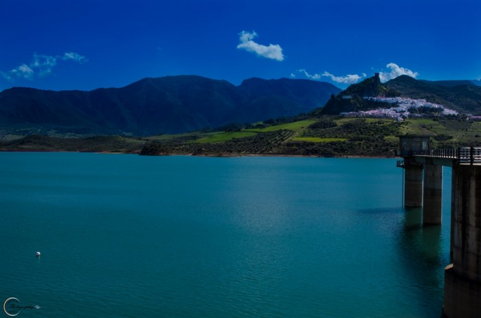 Reservoir with mountains and a white village on a hill