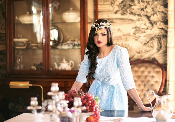 Woman with floral headpiece in ornate room