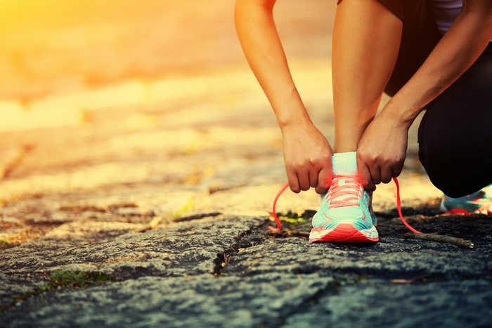 Person tying running shoe laces outdoors