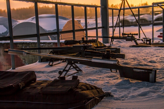 Sniper rifles on snow at sunset