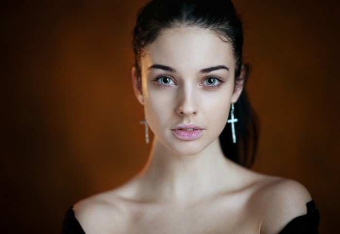 Portrait of a young woman with cross earrings