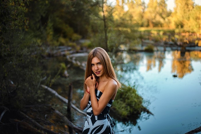 Woman in Nature by a Reflective Lake at Sunrise