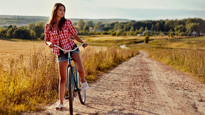 Woman on a bicycle on a dirt road