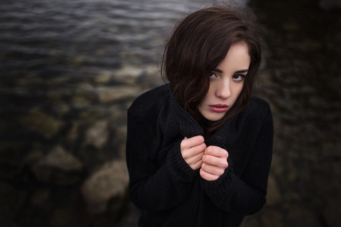 Woman in black sweater by the water