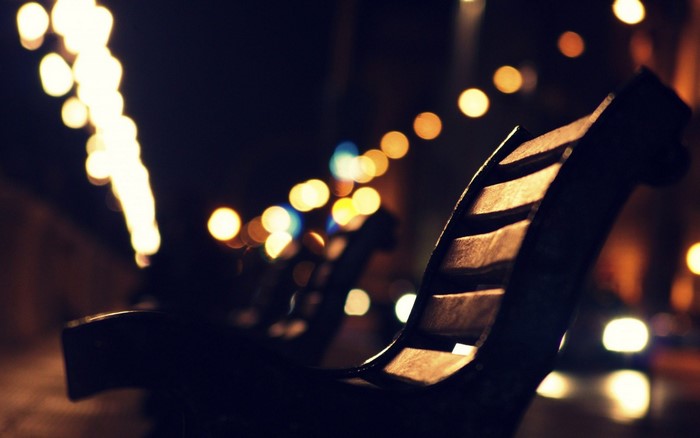 Bokeh lights and a park bench at night