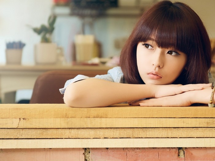 Thoughtful Woman Resting on Wooden Surface