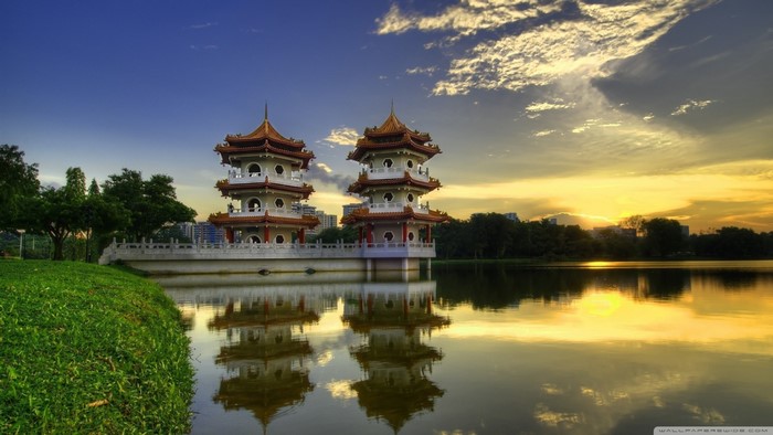 Two pagodas reflected in a lake at sunset
