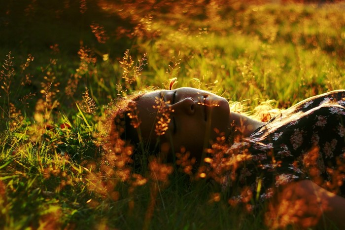 Woman lying in grass with sunlight