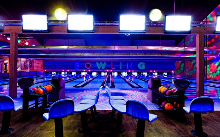 Bowling alley with neon lights and screens