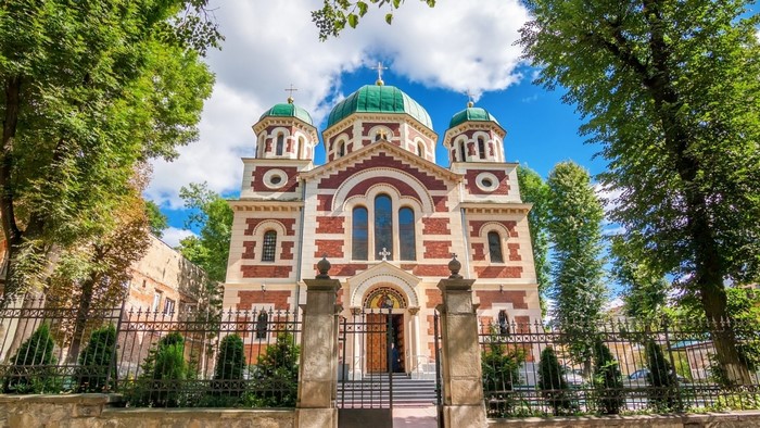 Church with green domes and red brick facade