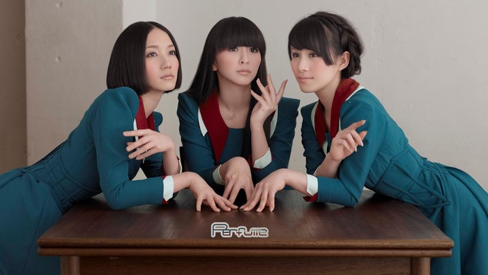 Perfume band members posing at a table