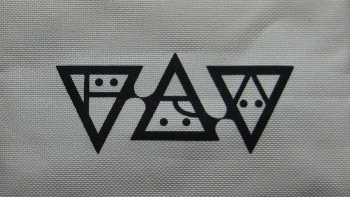 Black geometric logo with triangles and dots on gray fabric