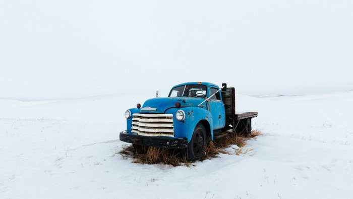 Blue Chevrolet flatbed truck in a snowy field
