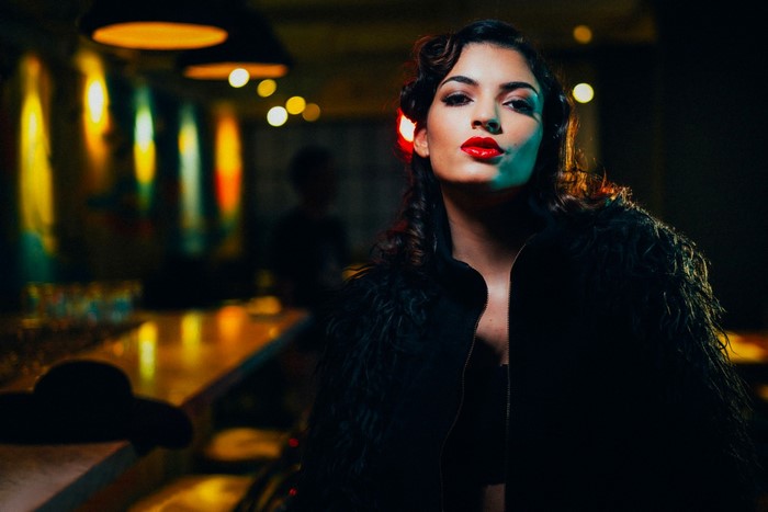 Woman with red lipstick in a dark bar