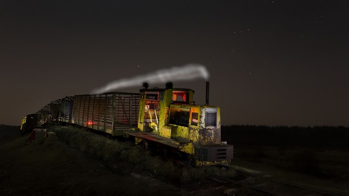 Old yellow train with carriages at night