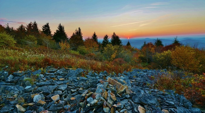 Autumn mountain landscape at sunset with rocky foreground