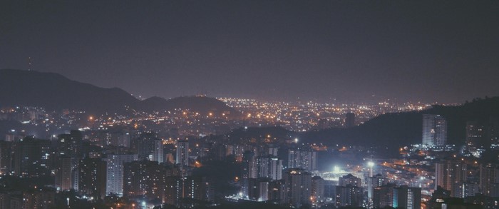 Cityscape at night with mountains in the background