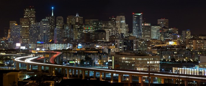 San Francisco cityscape at night with light trails on highway