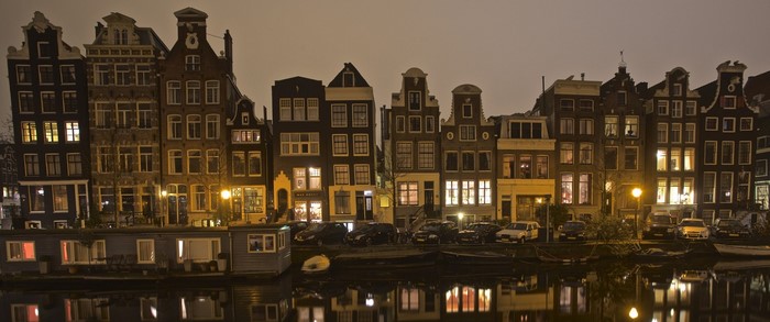 Amsterdam canal houses at night with reflections