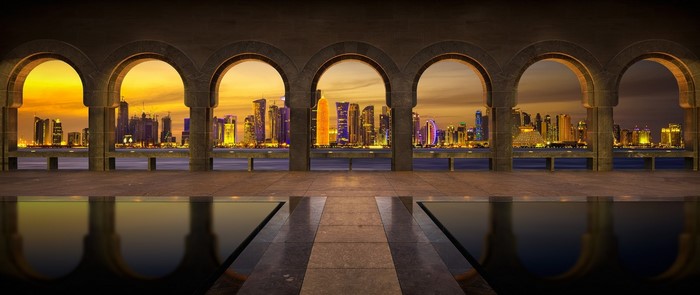 Museum of Islamic Art Doha skyline at sunset through arches
