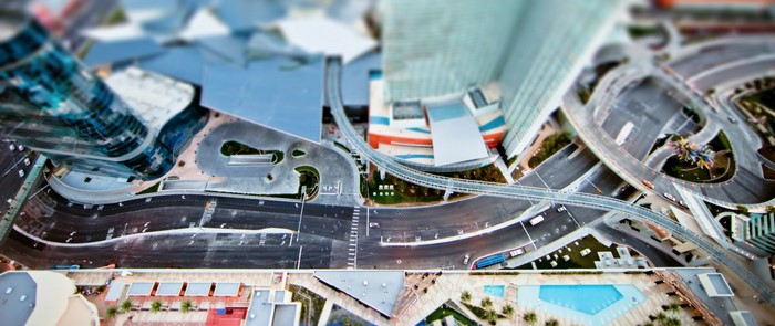 Aerial tilt-shift view of a modern city with roads and buildings