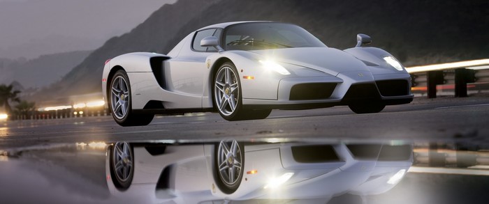 Silver Ferrari Enzo on wet road with reflection