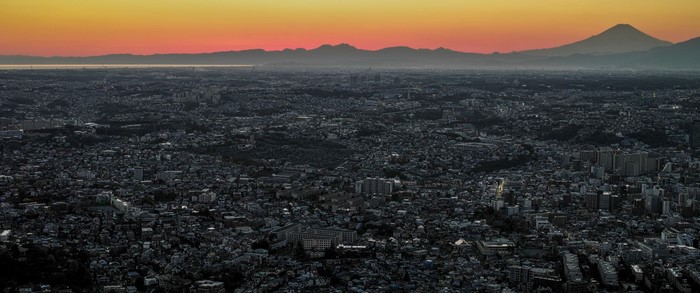 Cityscape at sunrise with mountains on the horizon