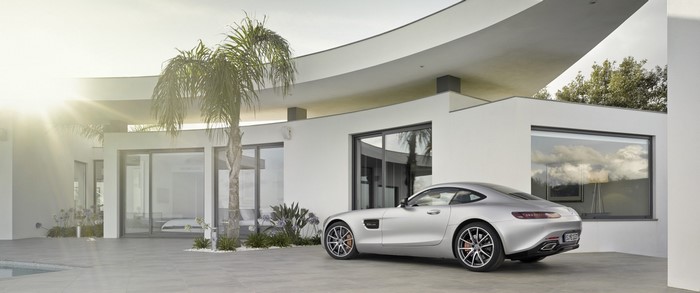 Silver Mercedes-AMG GT parked in front of a modern white house
