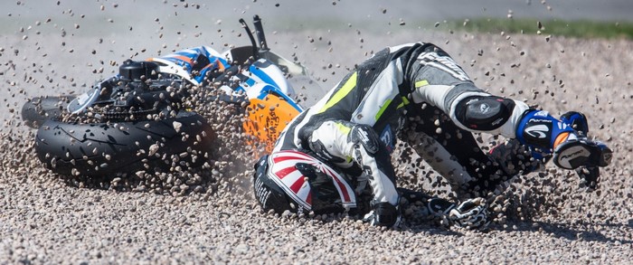 Motorcycle racer crashes on a gravel track